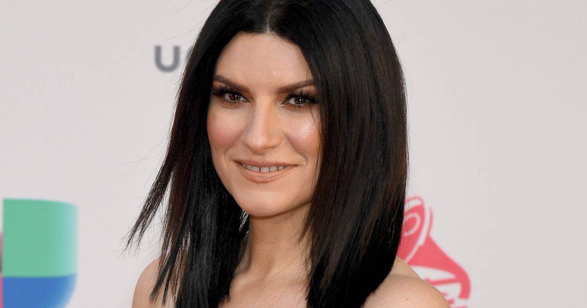 Laura Pausini col suo outfit per Natale tailleur e coccarda rossa è meravigliosa